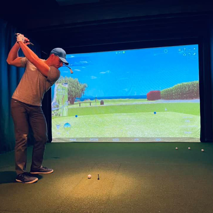 Caddy Shack Golf Pub | location interior backroom with golf simulator patron enjoying golf game | Decatur IL